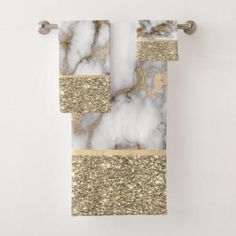 a gold and white towel hanging on a wall