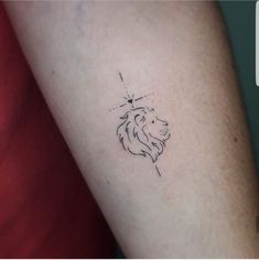 a small lion tattoo on the arm