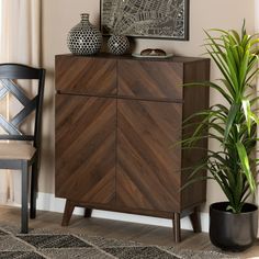 a wooden cabinet sitting next to a plant in a living room