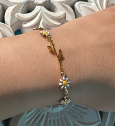 This stunning bracelet features a delicate chain of daisy flowers and a gorgeous golden stainless steel branch with leaves. The combination of the two creates a unique and beautiful design that is perfect for anyone who loves nature-inspired jewelry. The daisy flowers add a touch of playfulness and whimsy to the bracelet, while the golden stainless steel branch and leaves create an elegant look. The bracelet is perfect for any occasion, whether you're dressing up for a special event or adding a touch of elegance to your everyday look. Get your bracelet now and add a touch of nature to your jewelry collection! Measurement: 14cm + 6 inch extender Silver Flower Bracelet, Branch With Leaves, Butterfly Charm Bracelet, Daisy Bracelet, Birthday Bracelet, Floral Bracelet, Natural Stones Necklace, Freshwater Pearl Bracelet, Daisy Earrings