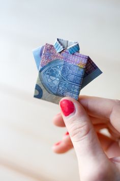 a woman's hand holding an origami bird