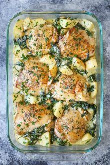 chicken and spinach casserole in a glass dish on a gray table top