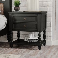 a black night stand with two drawers and a white vase on the end table next to it