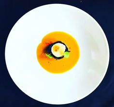 a white plate topped with an orange soup