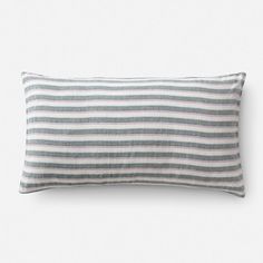 a gray and white striped pillow sitting on top of a bed