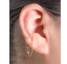 "This Simple and eye-catching Hoop Earring with Double Chain is very comfy, perfect for everyday wear and can be worn alone or combined with other earrings and cuffs. * Your choice of materials is: Sterling Silver, Rose Gold Filled or Gold Filled. Please choose from the drop-down menu. * Measurements: Conch Hoop inner diameter 10, 11 or 12 mm. Wire Thickness 20 Gauge. * Materials: 14K Gold Filled or .925 Sterling Silver cuff and chain. * Nickel and Lead Free (Hypoallergenic) perfect for sensitive skin. * 100% top quality USA materials.  * Your new jewelry ships nicely wrapped in a jewelry box, ready for gift giving. * No piercing? No problem!! I also have a listing in a \"Cuff\" version:   https://www.etsy.com/listing/827558987/conch-ear-cuff-earring-with-dangling * If you like what you se Earring Cuff Chain, Conch Hoop, Cuff Earring, Conch Earring, Piercing Ideas, Ear Cuff Earings, Conch Piercing, Minimal Jewelry, Gold Filled Earrings