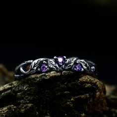 three stone ring sitting on top of a rock