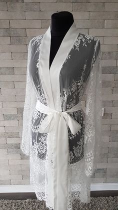 Off-white luxurious wedding robe, to add a perfect touch to your perfect and unique day. Only high quality fabrics and high finishing used for making the robe as neat as it can be. Please find the wedding robes collection here https://www.etsy.com/shop/LidiasBoutiqueDesign?ref=seller-platform-mcnav&section_id=25023222. For wedding dresses, please access https://www.etsy.com/shop/LidiasBoutiqueDesign?ref=seller-platform-mcnav§ion_id=23157290. For wedding tops and boleros, please access https: Elegant Wrap Kimono For Wedding Night, Elegant Lace Gown For Wedding Night, Long Lace Robe For Wedding Night, Feminine Lace Wedding Robe, Elegant Bridesmaid Lace Dress, Elegant Wedding Gown With Delicate Lace, Long Sleeve Delicate Lace Dress For Wedding Night, Elegant Open Front Kimono For Wedding, White Lace Nightgown For Wedding