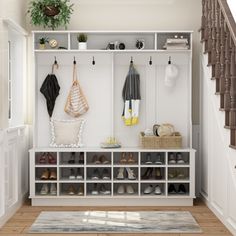 an entryway with shoes and umbrellas hanging on the wall, next to stairs