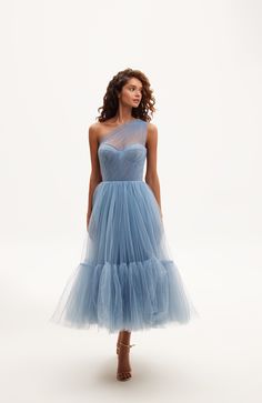 This light blue one-shoulder A-line midi dress features a puffy tulle skirt with a short underskirt, a lace-up corset bustier, and an asymmetrical sheer sleeve. Material: Tulle Composition: 100% polyester Skirt length from waist: 35.4 inches Dress weight: 17.6 lbs Neckline: Heart-shaped Back: Lace-up corset Built-in cups Lining: Light blue short underskirt Machine wash gentle cycle up to 86°F Do not bleach Steam up to 250°F Dry cleaning allowed Do not tumble dry Dry vertical Store hanging with i Fitted One-shoulder Tulle Evening Dress, One Shoulder Tulle Skirt Dress For Wedding, One-shoulder Tulle Gala Dress, Elegant Evening One-shoulder Tulle Dress, Gala One-shoulder Tulle Evening Dress, One Shoulder Tulle Cocktail Dress, One-shoulder Tulle Cocktail Dress, Elegant One-shoulder Fitted Tulle Dress, Tulle One Shoulder Dress For Prom