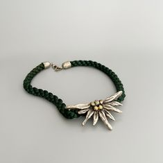 Beautiful vintage Bavarian Edelweiss flower necklace.  Emerald green braided silk cord and metal.  Edelweiss is a favorite motif in Bavarian women's jewelry for a dirndl (Bavarian traditional dress) or costume. ⚜️Good vintage condition with traces of use.  But that's exactly what separates vintage treasures from modern pieces ⚜️More Bavarian vintage: https://www.etsy.com/de/shop/JDVintageDE ⚜️Dimensions: Necklace : 43 cm  Edelweiss : 7.5 cm x 4 cm  Extension chain : 5.5 cm  ⚜️Shipment :  from Ge Folklore Jewelry, Edelweiss Necklace, Edelweiss Jewelry, Edelweiss Flower, Necklace Emerald, Costume Necklaces, Silk Cord, Traditional Dress, Jewelry For Women