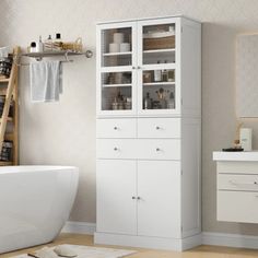 a white bath tub sitting next to a wooden shelf filled with towels and other items