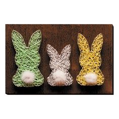 three different colored bunny ears with pom - poms on them