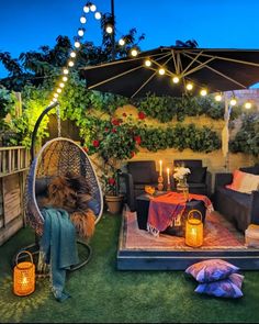 an outdoor living area is decorated with lights and furniture, including a hammock chair