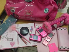 the contents of a pink purse are laid out on a table next to other items