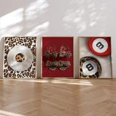 three framed pictures on the wall with animal print and red plates in front of them