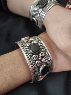 * This traditional craft is embellished with black stones and intricate carved designs, inspired by the true Afghani ornaments. The light in weight, yet exclusive bracelet would add an ethnic touch to your attire. The pick tiny stones are complimenting the tribal style of the hand accessory. You can pair this elegant ornament with any traditional or trendy attire, as per your liking. Note: The product is handmade, so slight change might occur in the actual product. Adjustable Oxidized Finish Bracelets For Festival, Adjustable Oxidized Festival Bracelets, Traditional Metal Bangle Bracelets, Bohemian Adjustable Cuff Bracelet With Intricate Design, Bohemian Bracelets With Oxidized Finish, Handmade Silver Cuff Bracelet For Rituals, Metal Bracelets For Rituals, Traditional Oxidized Finish Bracelets As A Gift, Bohemian Oxidized Bangle For Festivals