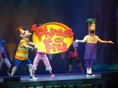 the children are performing on stage with their hands in the air while wearing costumes that read phineas and fer