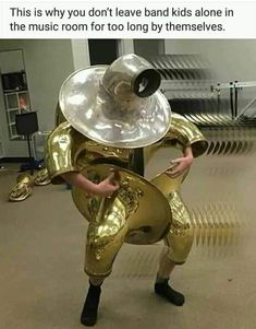 a man dressed in gold holding a large metal object