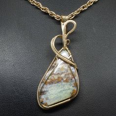 "Details About This Pendant: The contemporary stone pendant is hand crafted using fine precious metal wire and natural gemstone to form this stunning delicate enhancer. The bail is large enough to accommodate various styles of chains. It is not mass produced nor manufactured. *Natural Peruvian Blue Opal Gemstone (30mm x 25mm Triangle Shaped). *Pendant Size: 2 1/2\" long including bail x 1\" at widest point. Includes free 18\" chain. *Precious metal is lead free, nickel free, does not tarnish. To Triangle Wire Wrap Pendant, Handmade Opal Jewelry, Contemporary Handmade Jewelry, Wire Wrap Cabochon, Wire Wrap Jewelry Designs, Peruvian Blue Opal, Wire Wrapped Jewelry Tutorials, Bijoux Fil Aluminium, Jewelry Opal