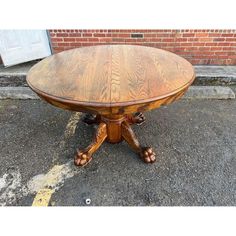 a wooden table sitting on top of a sidewalk next to a brick wall and door