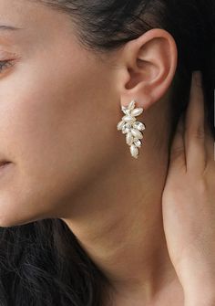 a close up of a person wearing some kind of earring with flowers on it