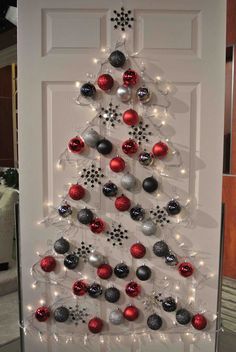 a white door with a christmas tree made out of ornaments on the front and side