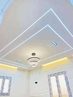 an empty room with white walls and blue trim around the ceiling is lit by recessed lights