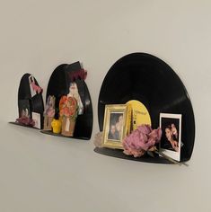 two black records with pictures on them and flowers in vases next to each other