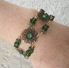 "This beautiful bracelet has seed beads, green Czech glass beads, antique gold accent beads and antique gold filigree settings accented with rhinestones. 7\" long. Toggle clasp." Elegant Bangle Bracelet With Antique Finish, Elegant Antique Finish Bangle Bracelet, Adjustable Antique Finish Wedding Jewelry, Antique Finish Adjustable Wedding Jewelry, Handmade Czech Glass Bracelet, Elegant Antique Gold Bracelet Jewelry, Elegant Bronze Bracelets For Wedding, Elegant Bangle Jewelry With Antique Finish, Elegant Antique Finish Bangle