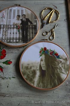 two embroidery hoops with pictures on them next to scissors and some flowers in front of a fence