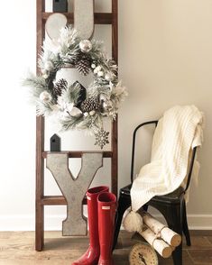 a christmas wreath and boots are next to a ladder