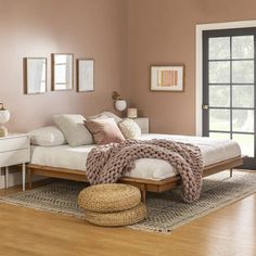 a bedroom with pink walls and white furniture