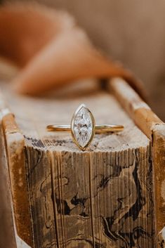 a diamond ring sitting on top of a piece of wood