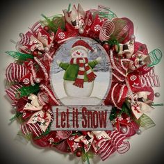 a red and green wreath with a snowman on it that says let it snow