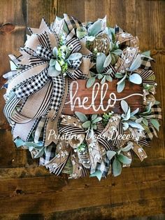 a wreath with the word hello is hanging on a wooden wall next to a door