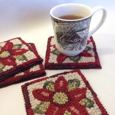 three crocheted coasters on a table with a cup of tea