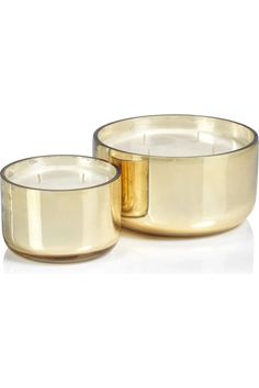 two gold colored candles sitting next to each other