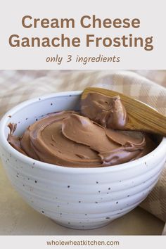 a white bowl filled with chocolate ganache frosting on top of a wooden spoon