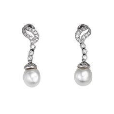 Elegant pair of vintage diamond & baroque pearl earrings crafted in 14k white gold (circa 1950s to 1960s).    Round brilliant diamonds total an estimated 0.50 carats (estimated at H-I color and VS2-SI2 clarity). The pearls measure 10.5mm each.    The elegant drop earrings exude glamor and style and make a great statement on the earlobe. Diamonds adorn the scrolled mounts with lustrous pearls to the base. The earrings are great for day or evening wear & are fitted with post & hinged omega backings for pierced ears.    The earrings are in very good condition and were recently lightly cleaned and polished.    Particulars:    Weight: 9.6 grams    Stones: Round brilliant diamonds total an estimated 0.50 carats (estimated at H-I color and VS2-SI2 clarity). The pearls measure 10.5mm each.    Size Pearl Diamond Earrings, Baroque Pearl Earrings, Pearl And Diamond Earrings, Earring Crafts, Pearl Diamond, Brilliant Diamond, Vintage Diamond, Baroque Pearls, Round Brilliant