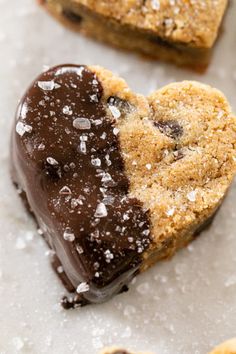 two heart shaped cookies with chocolate frosting and sprinkles on the top