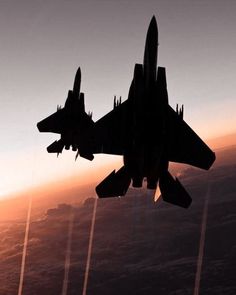 a fighter jet flying through the air at sunset