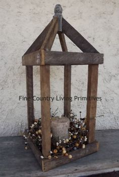 a small wooden bird feeder with a candle in it