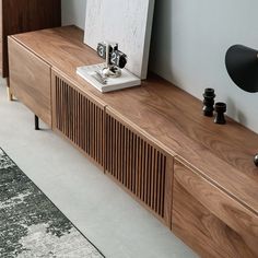 a wooden entertainment center with two speakers on it's sides and an art piece on top