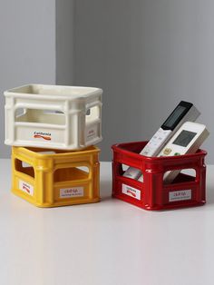 three plastic containers sitting on top of a white table next to each other with electronic devices in them