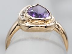 Here we've taken a vintage gold and champagne diamond mounting and set it with our own stone! This is a wonderful gem, an amethyst with precise faceting and with rich, deep color. The teardrop, pear-shaped cut reflects a great deal of light from within the stone! This luxurious piece will transition well from office to evening!Metal: 14K Yellow GoldGem: Amethyst 1.70 CaratsGem Measurements: 9.4 x 6.7 mm, PearAccents: 5 Diamonds totaling .08 Carats, SI in Clarity, Champagne in Color Ring Size: 6.75Marks: “14K” Stamped on the inside band Luxury Vintage Gold Amethyst Ring, Yellow Gold Amethyst Ring, Champagne Diamond Ring, European Cut Diamond Ring, Yellow Gold Solitaire Ring, Champagne Diamond Rings, Purple Stone Rings, Gold Amethyst Ring, Green Tourmaline Ring