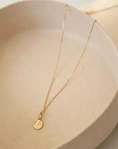 Arriya - a luminous strand of pure gold, this adjustable cable chain embodies delicate elegance. Its fine craftsmanship whispers sophistication, making it the ideal complement to our Mini Disc charm, whose textured surface dances with light at every turn. Personalize your necklace further by adding an array of charms, making Arriya uniquely yours. Delicate Charm Necklace With Oval Pendant And Adjustable Chain, Delicate Charm Necklace With Oval Pendant, Elegant Charm Necklace With Delicate Chain In Recycled Gold, Elegant Charm Necklaces With Delicate Chain In Recycled Gold, Elegant Recycled Gold Charm Necklace With Delicate Chain, Timeless Charm Necklace With Delicate Chain And Round Pendant, 14k Gold-filled Cable Chain Necklace With Round Pendant, Delicate Yellow Gold Charm Necklace With Round Pendant, 14k Gold Filled Cable Chain Necklace With Round Pendant