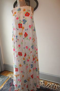 This pretty cotton sleeveless floral maxi dress by Saks Fifth Avenue is perfect for summer days.  Lovely floral pattern with little daisy trim around the neckline and arm holes.  It opens in the back with a 21 inch covered zipper, is fully lined, and has two side pockets.  It looks great worn as is or belted.  The garment may be hand washed or dry cleaned per the label.  No size label, but best suited for medium frames.  Measurements laid flat are: neckline/shoulders 11 inches, arm opening 9 inc Summer A-line Floral Lined Dress, Summer Floral A-line Dress, Summer A-line Floral Day Dress, Spring Daywear Maxi Dress With Ditsy Floral Print, Spring Maxi Dress With Ditsy Floral Print For Daywear, Spring Maxi Dress With Ditsy Floral Print, Spring Floral Maxi Dress For Daywear, White Full Length Spring Dresses, Sleeveless Ditsy Floral Maxi Dress For Summer