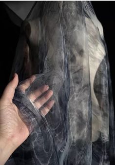 a person holding something in their hand while wearing transparent clothing