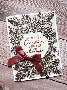 a handmade christmas card with red ribbon and pineconing on the front, which reads, may this be a christmas to remember hope